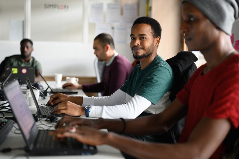 Deux hommes du programme refugeek qui travaillent 