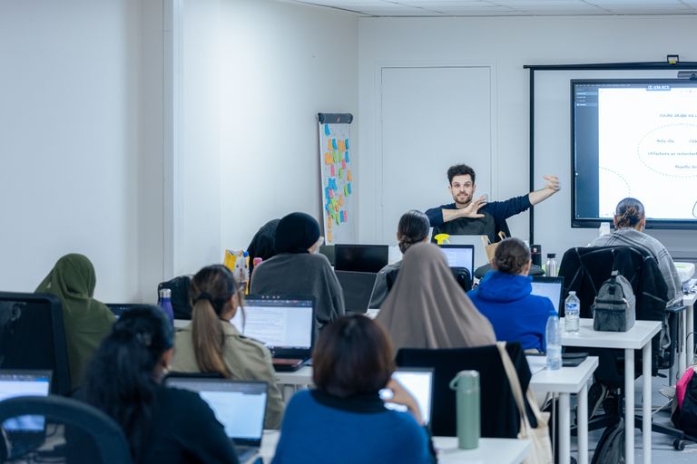 Photo du formateur en train de donner un cours à une classe composée exclusivement de filles